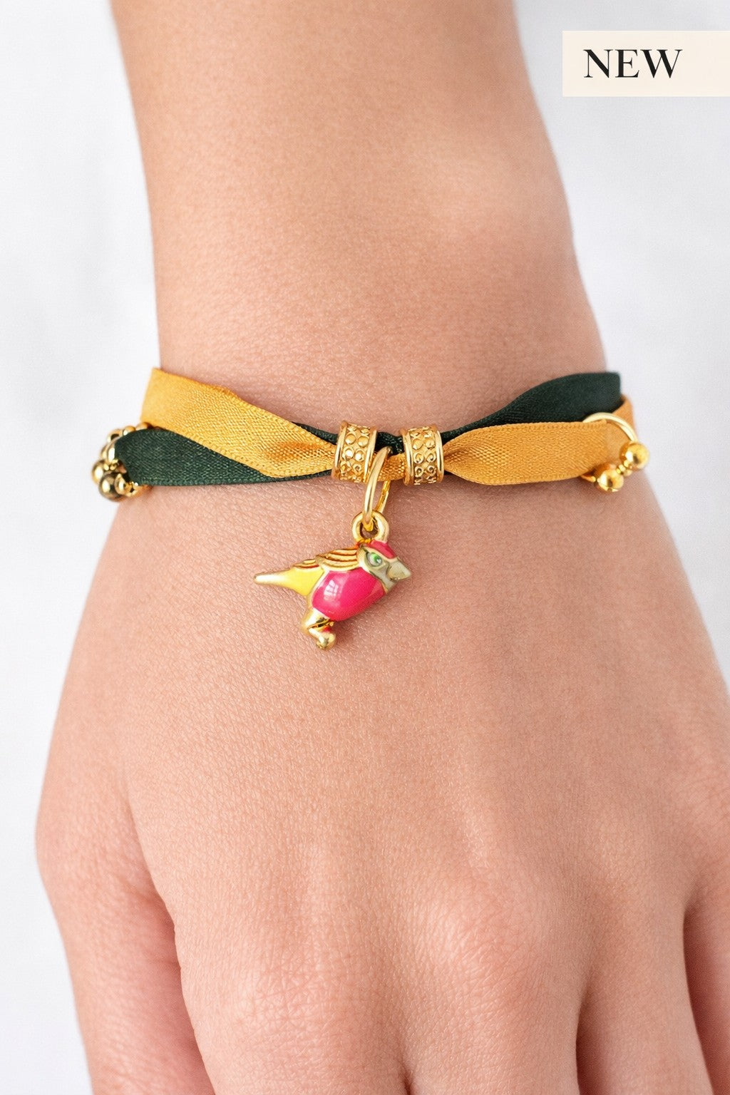 Pulsera de seda verde y mostaza con pajarita esmaltada