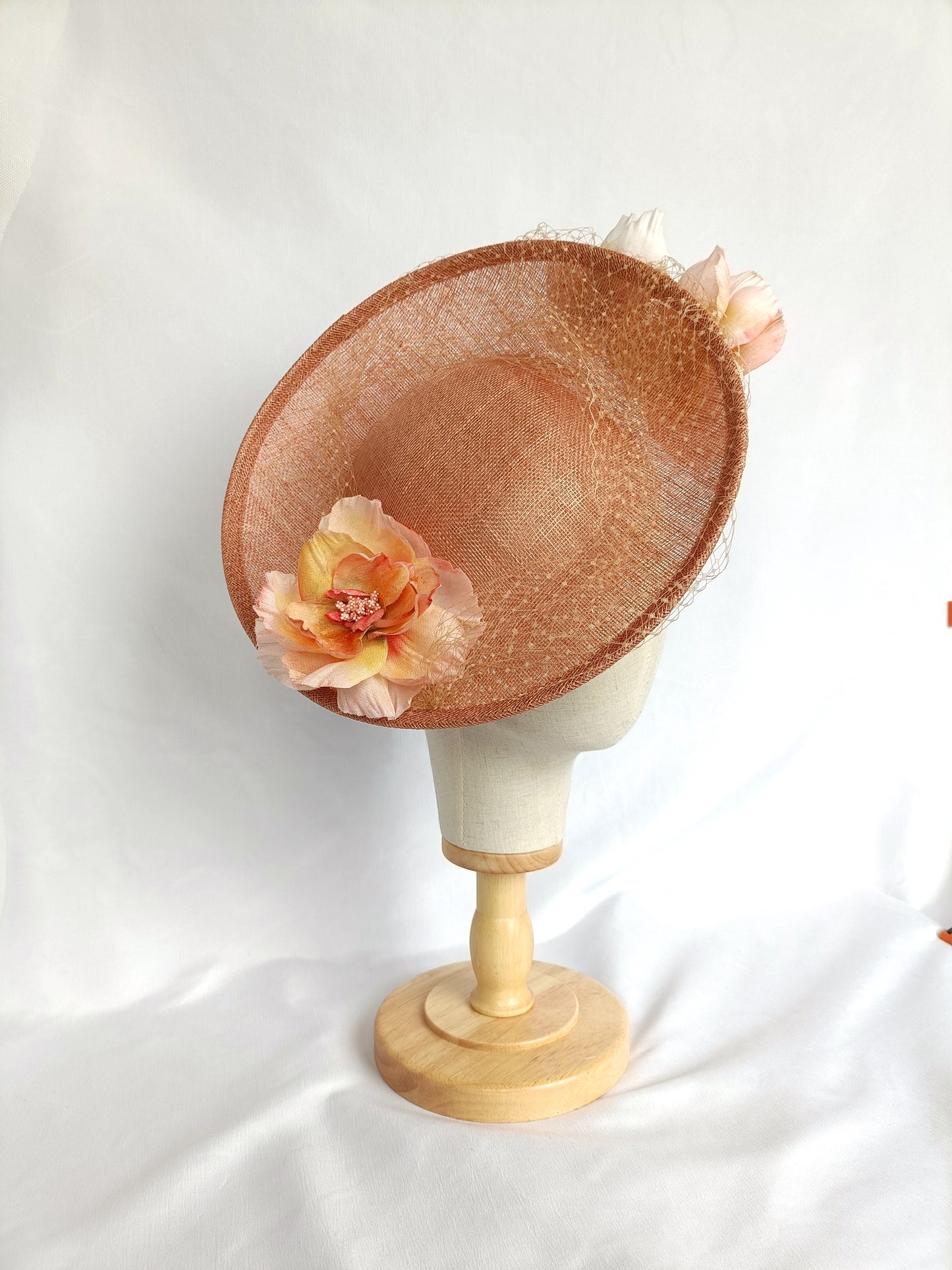 Tocado pamela de invitada en sinamay snaranjado, flores de seda azules y amarillas, con velo decorativo, elegante y colorido para boda.a