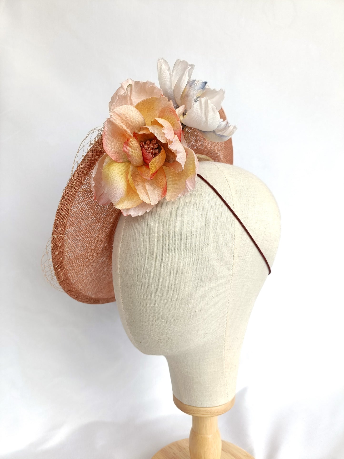 Tocado pamela de invitada en sinamay snaranjado, flores de seda azules y amarillas, con velo decorativo, elegante y colorido para boda.a