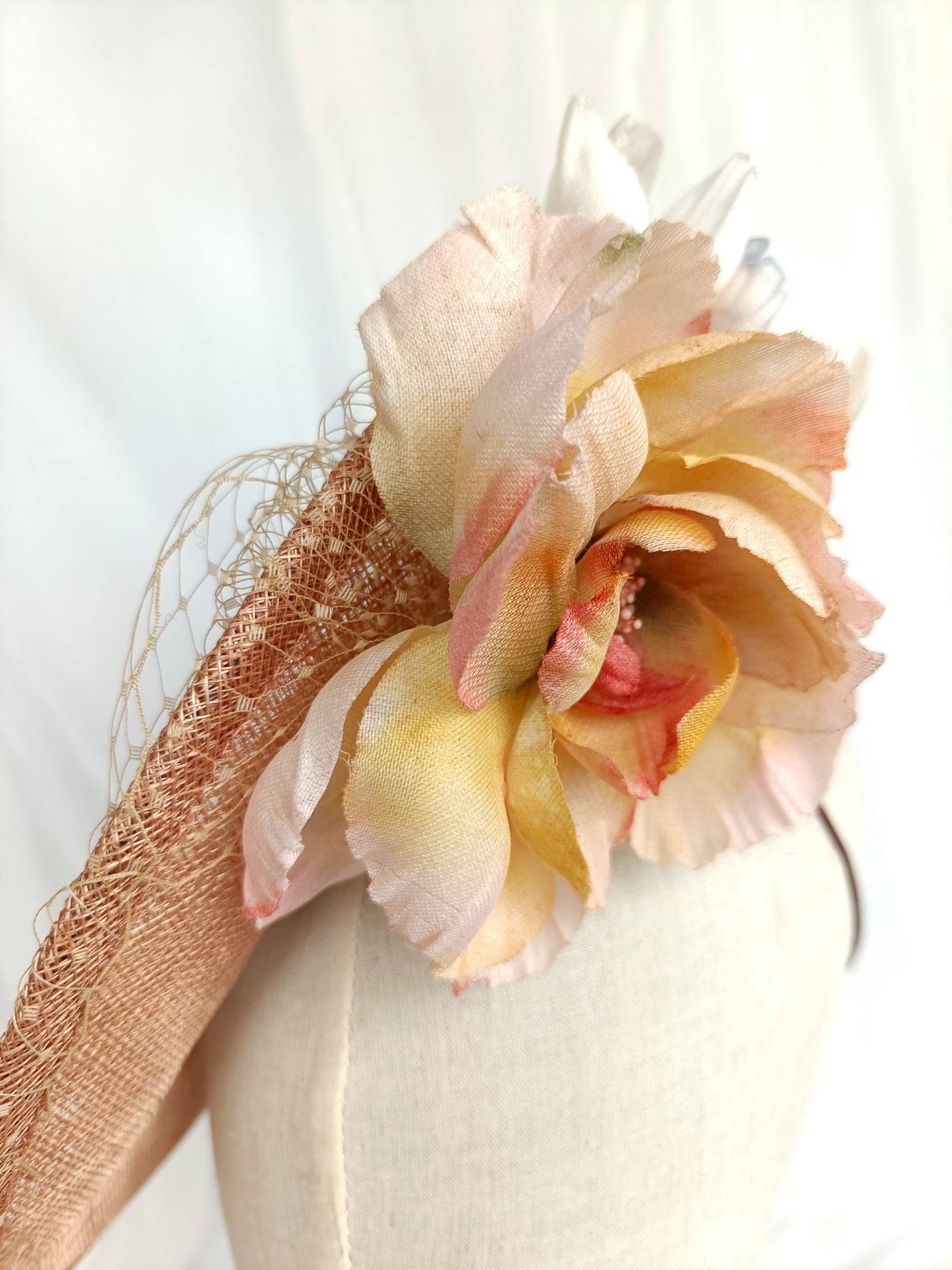 Tocado pamela de invitada en sinamay snaranjado, flores de seda azules y amarillas, con velo decorativo, elegante y colorido para boda.a