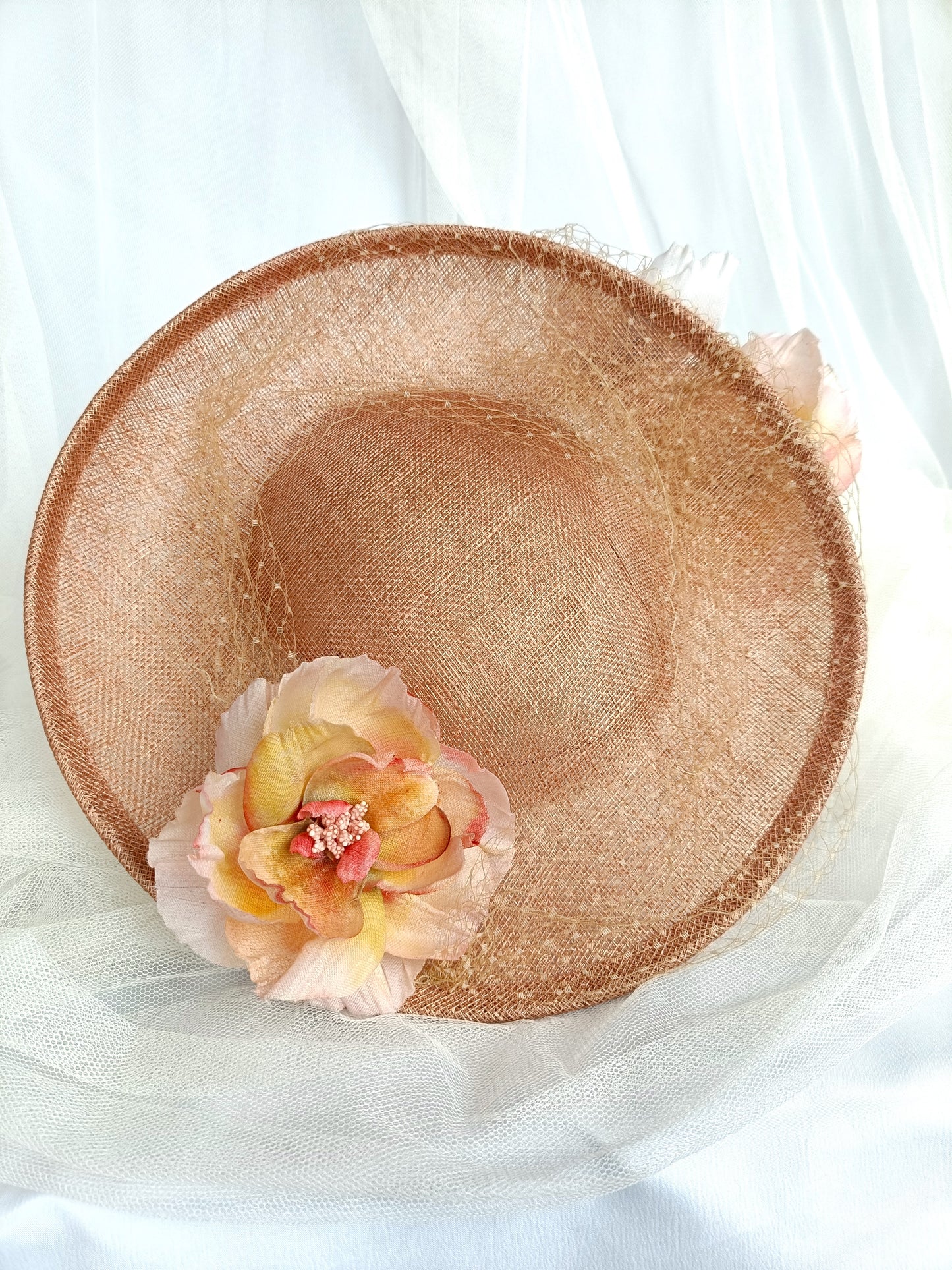 Tocado pamela de invitada en sinamay snaranjado, flores de seda azules y amarillas, con velo decorativo, elegante y colorido para boda.a