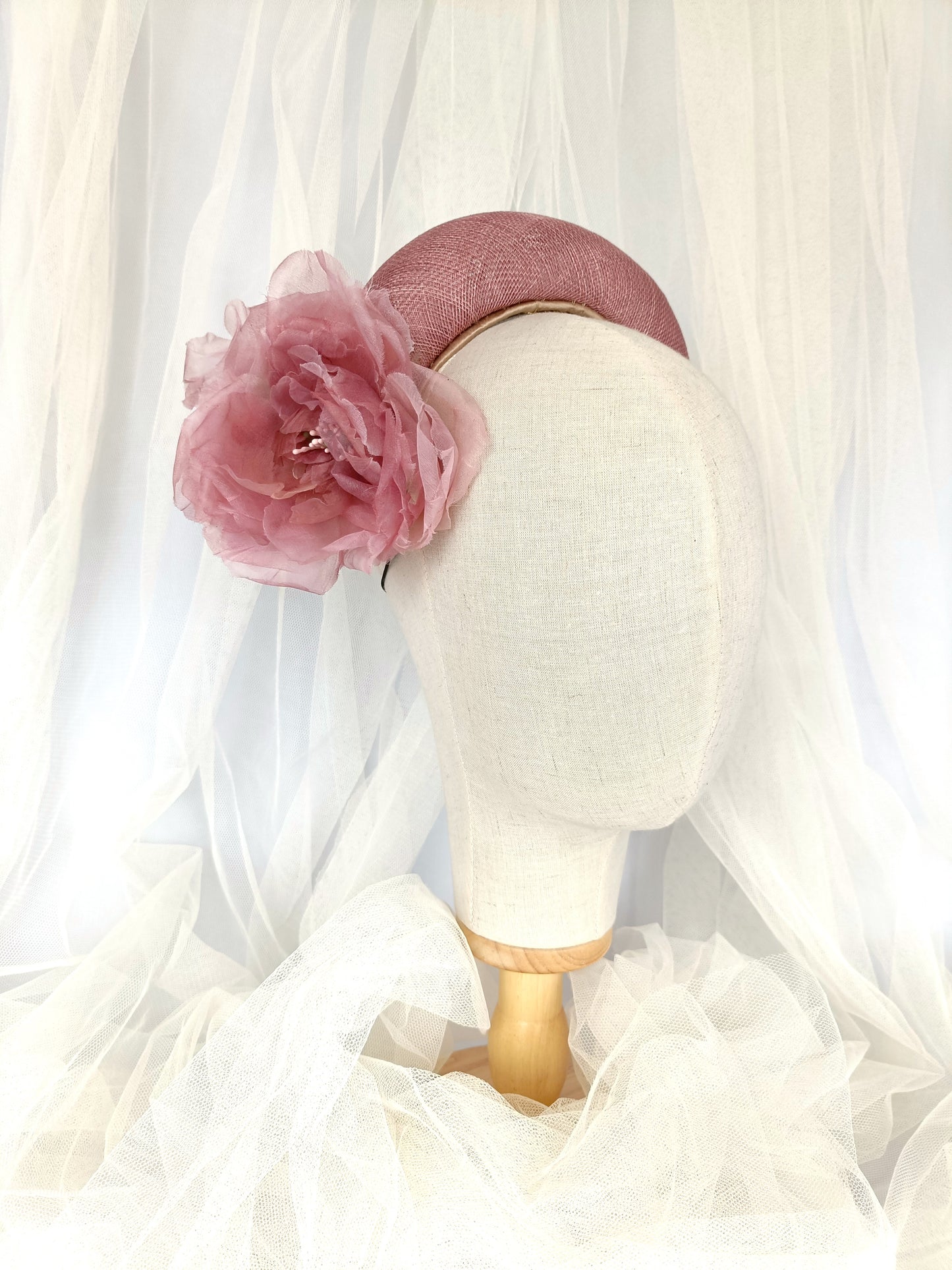 Diadema tocado en rosa palo con flores de organza, diseño elegante y romántico para invitada de boda o evento especial.