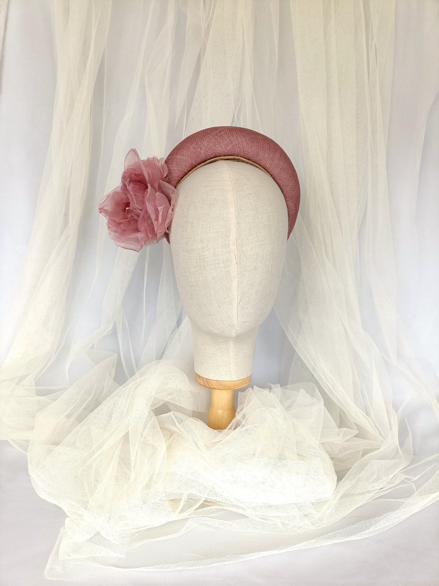 Diadema tocado en rosa palo con flores de organza, diseño elegante y romántico para invitada de boda o evento especial.