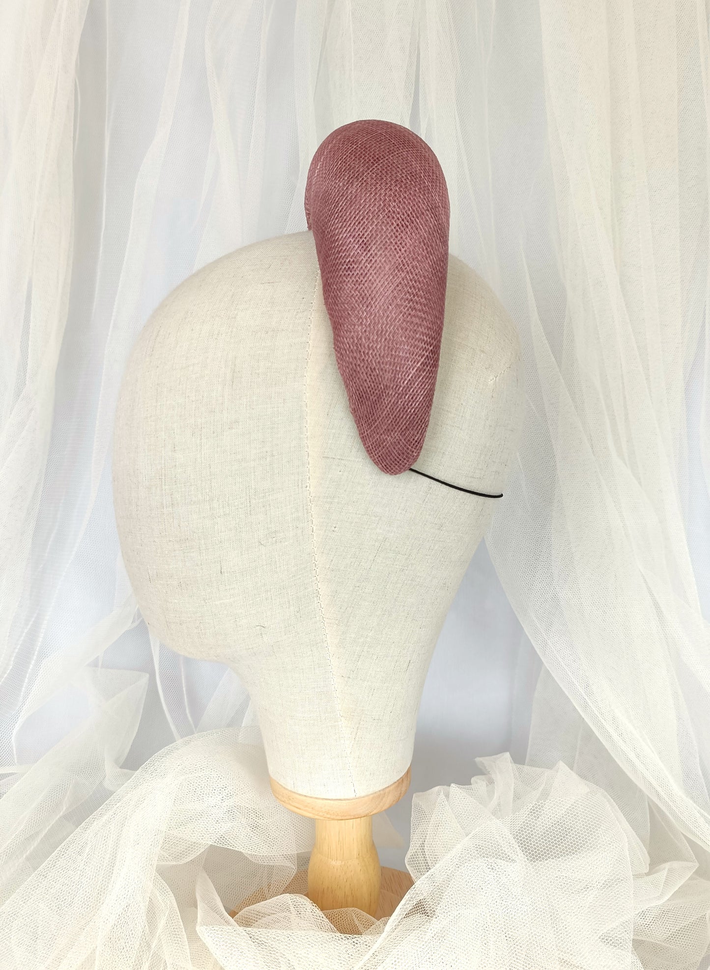 Diadema tocado en rosa palo con flores de organza, diseño elegante y romántico para invitada de boda o evento especial.