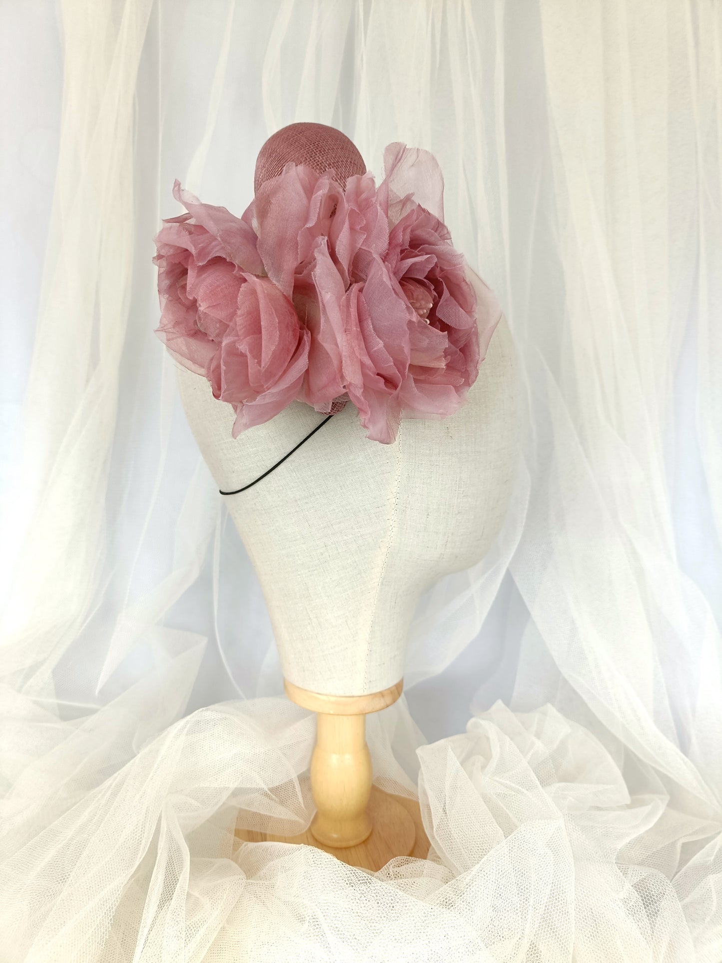 Diadema tocado en rosa palo con flores de organza, diseño elegante y romántico para invitada de boda o evento especial.