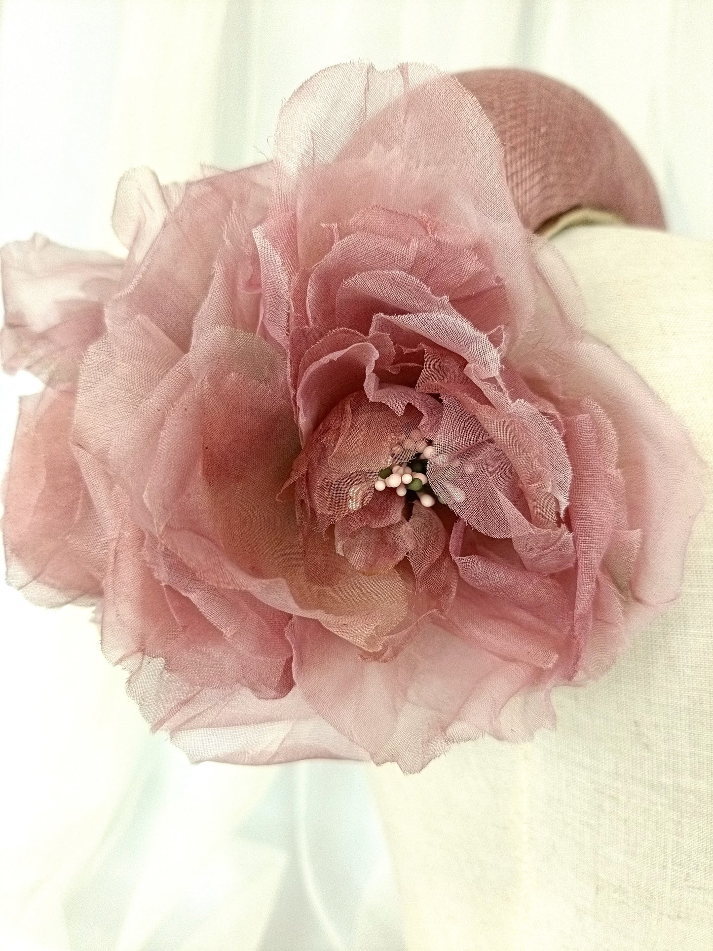 Diadema tocado en rosa palo con flores de organza, diseño elegante y romántico para invitada de boda o evento especial.