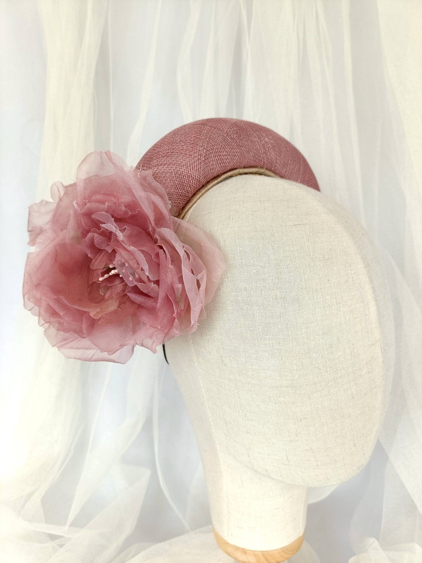 Diadema tocado en rosa palo con flores de organza, diseño elegante y romántico para invitada de boda o evento especial.