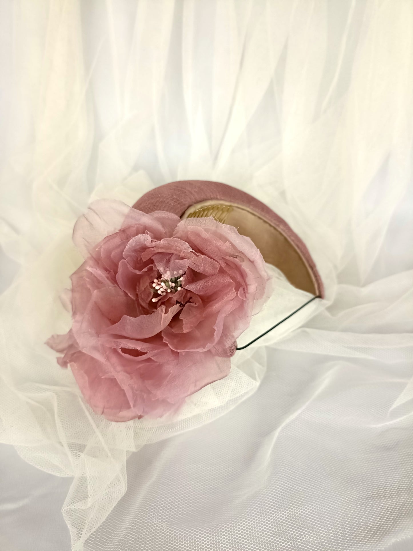 Diadema tocado en rosa palo con flores de organza, diseño elegante y romántico para invitada de boda o evento especial.