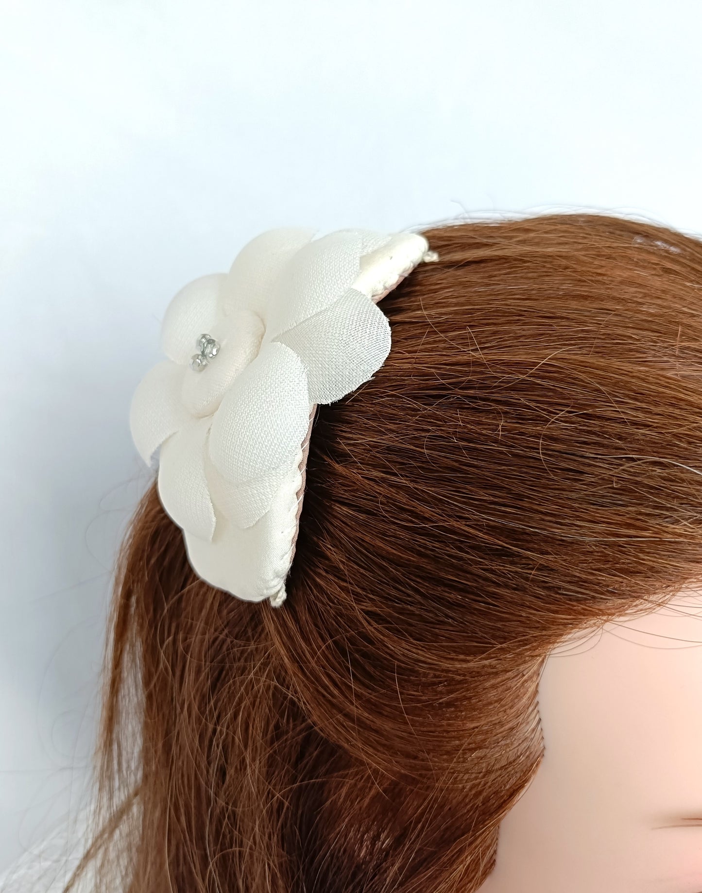Tocado elegante con flor de seda para novia.