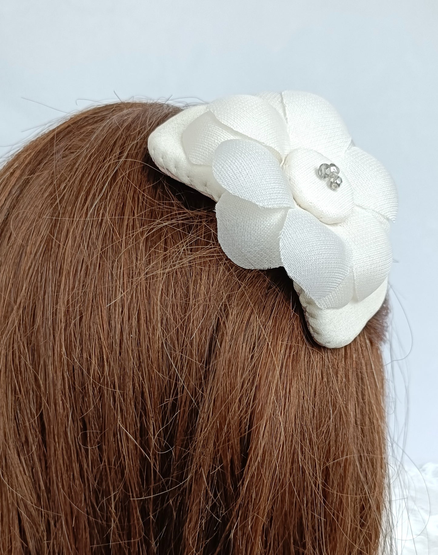Tocado elegante con flor de seda para novia.