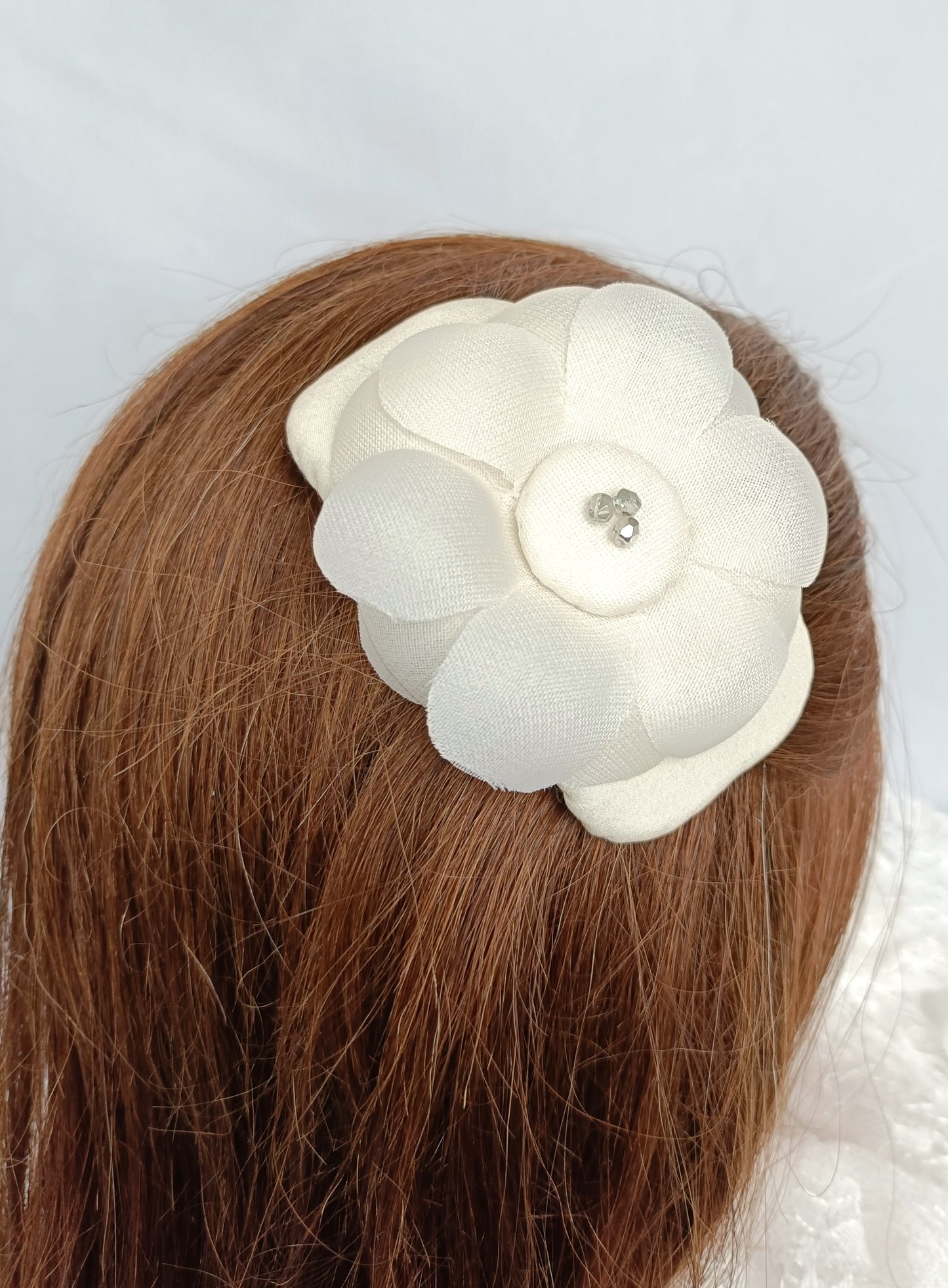 Tocado elegante con flor de seda para novia.