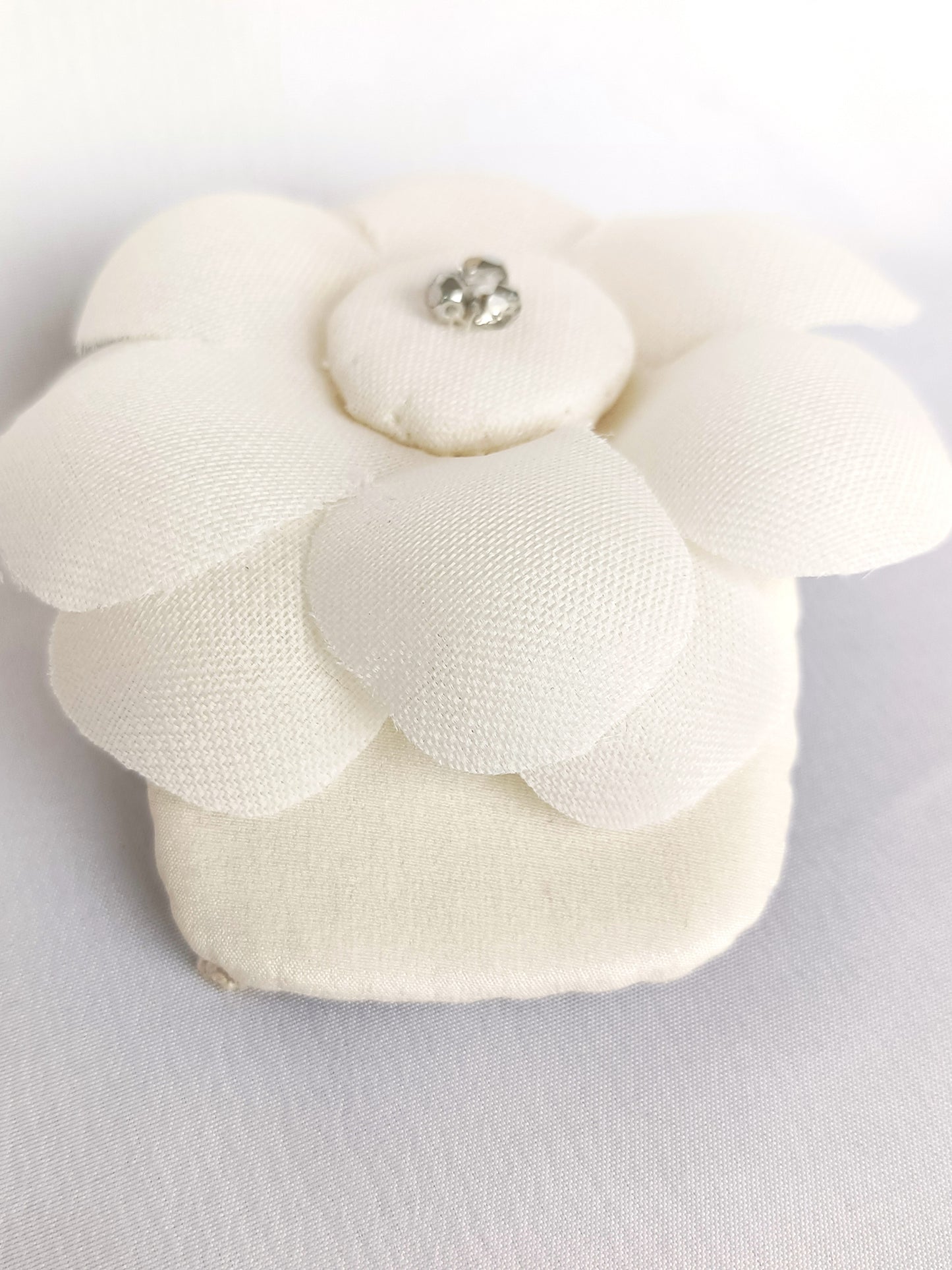 Tocado elegante con flor de seda para novia.