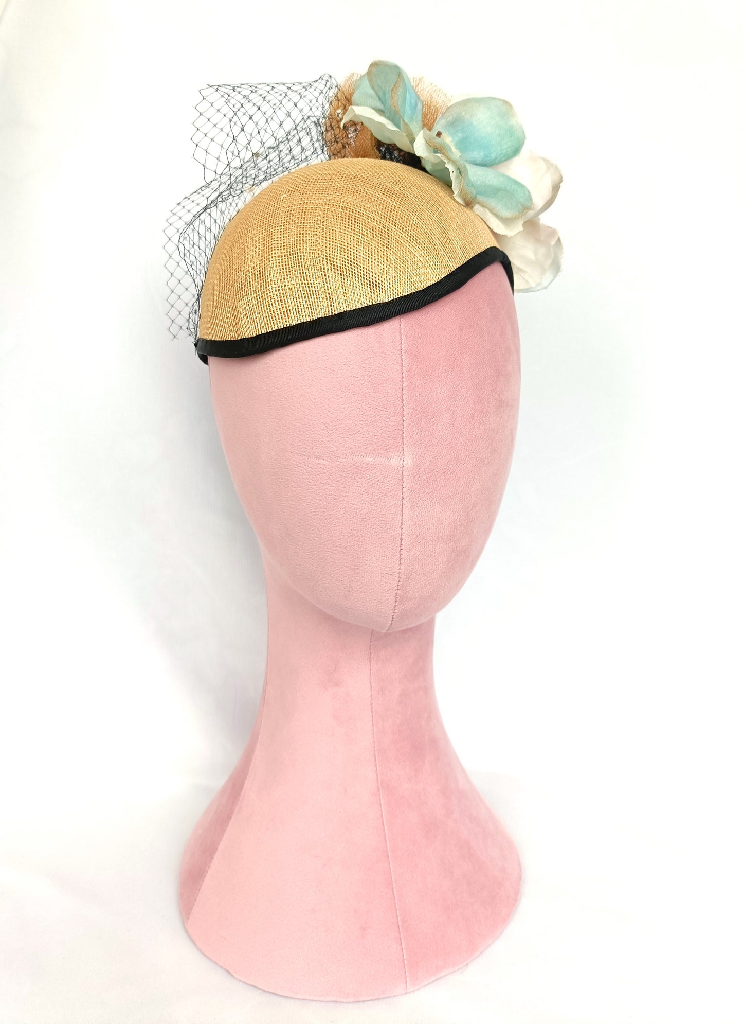 Tocado de sinamay con flores de seda y velo para invitada.