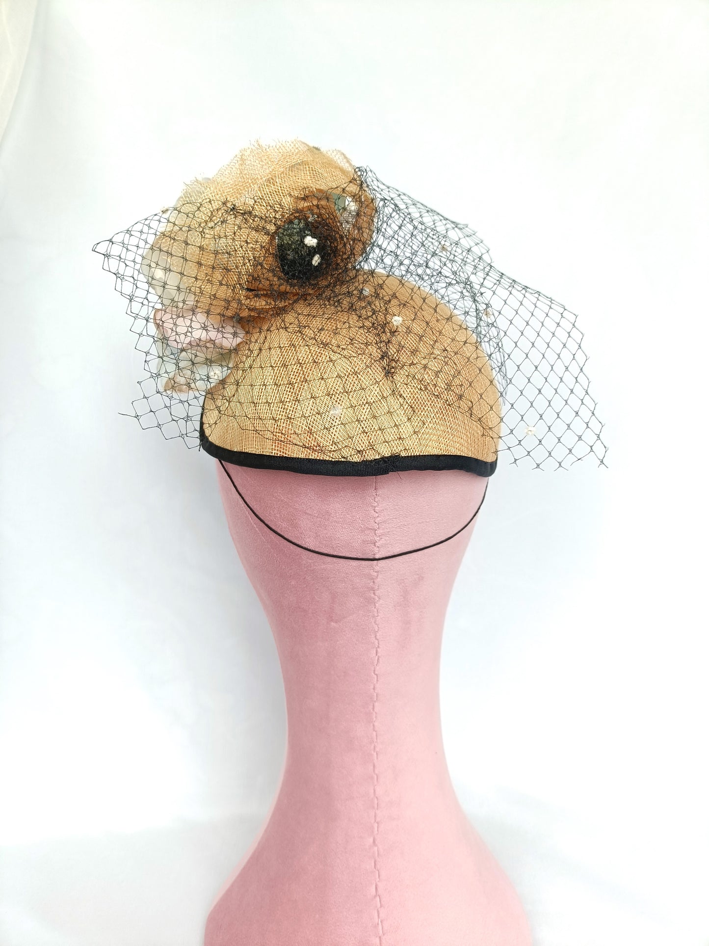 Tocado de sinamay con flores de seda y velo para invitada.