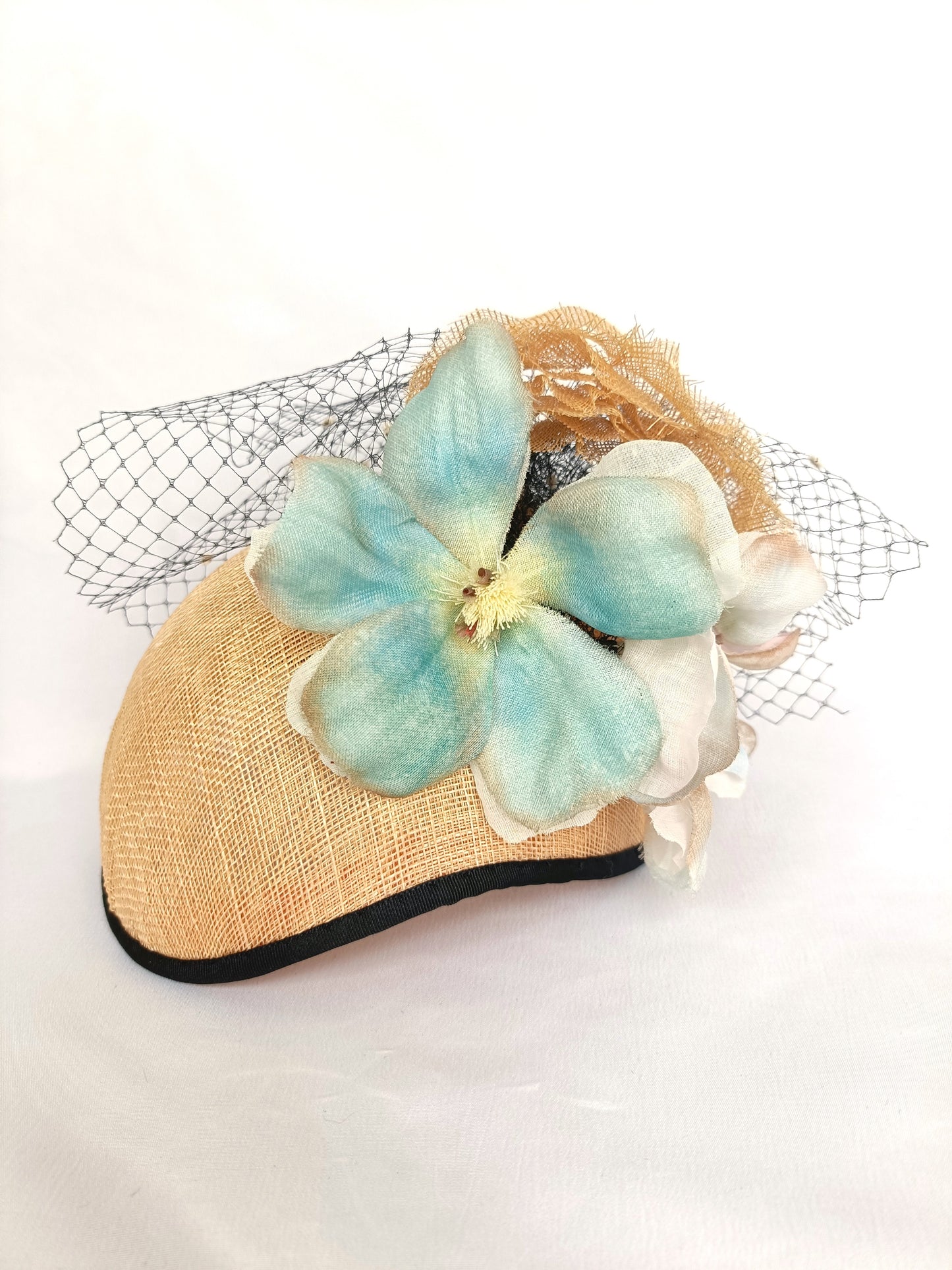 Tocado de sinamay con flores de seda y velo para invitada.