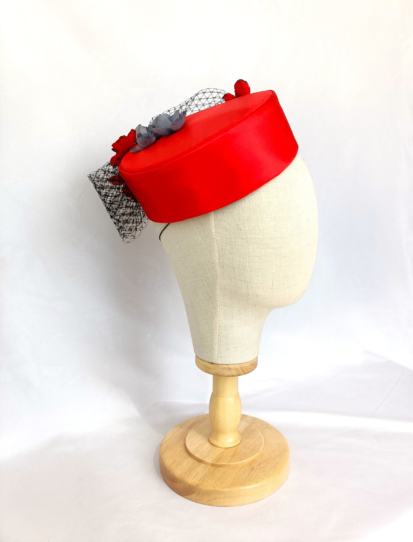 Tocado pillbox rojo de seda con flores artesanales.