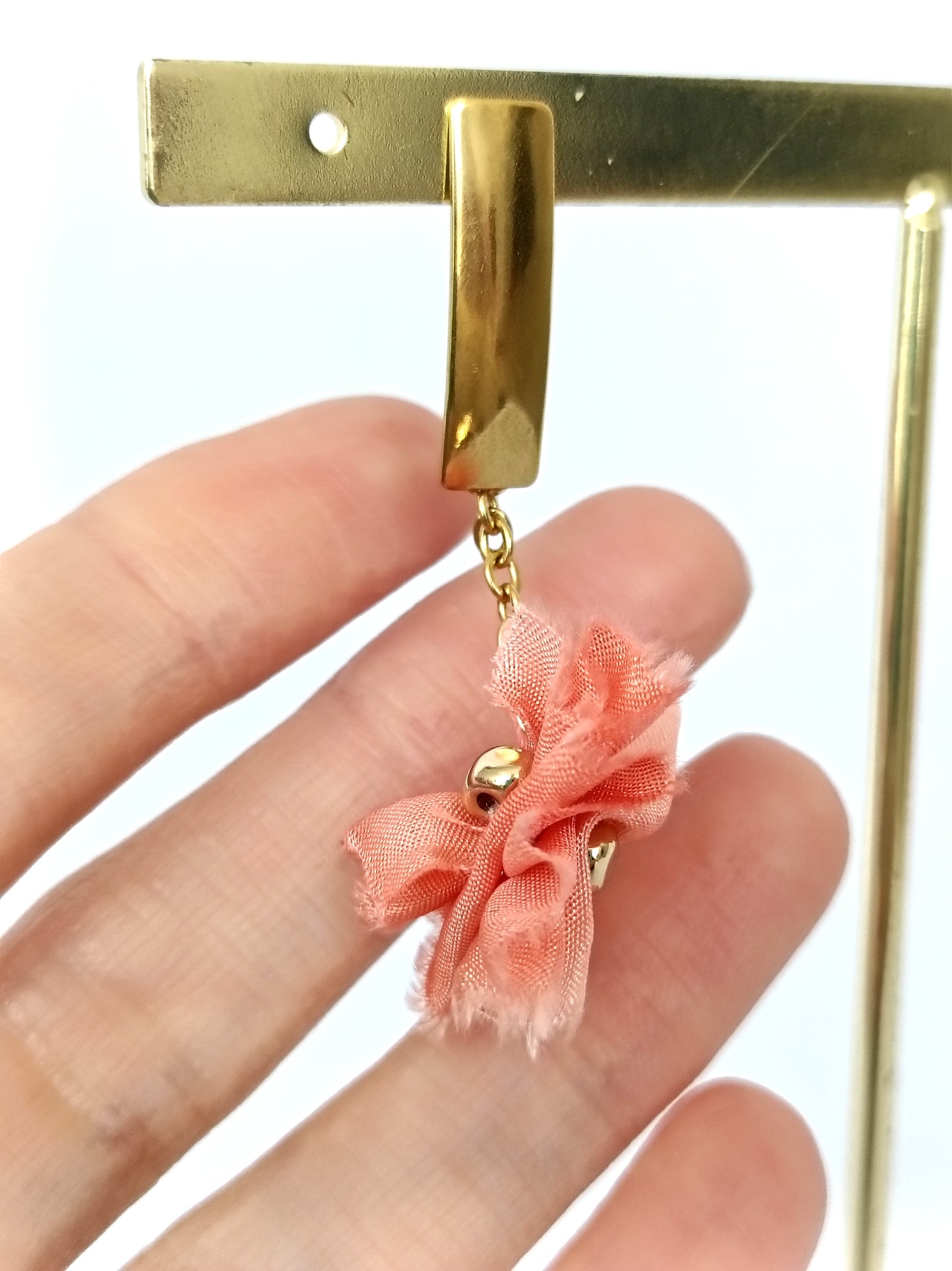 Pendientes elegantes de seda color salmón rosado.