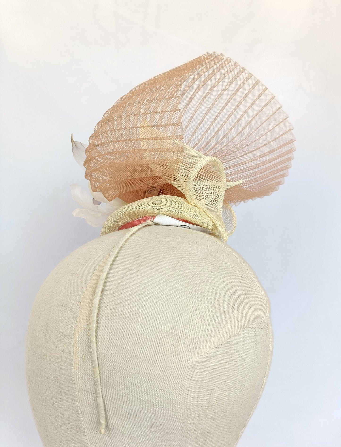 Tocado elegante beige de sinamay con flor de seda para bodas.