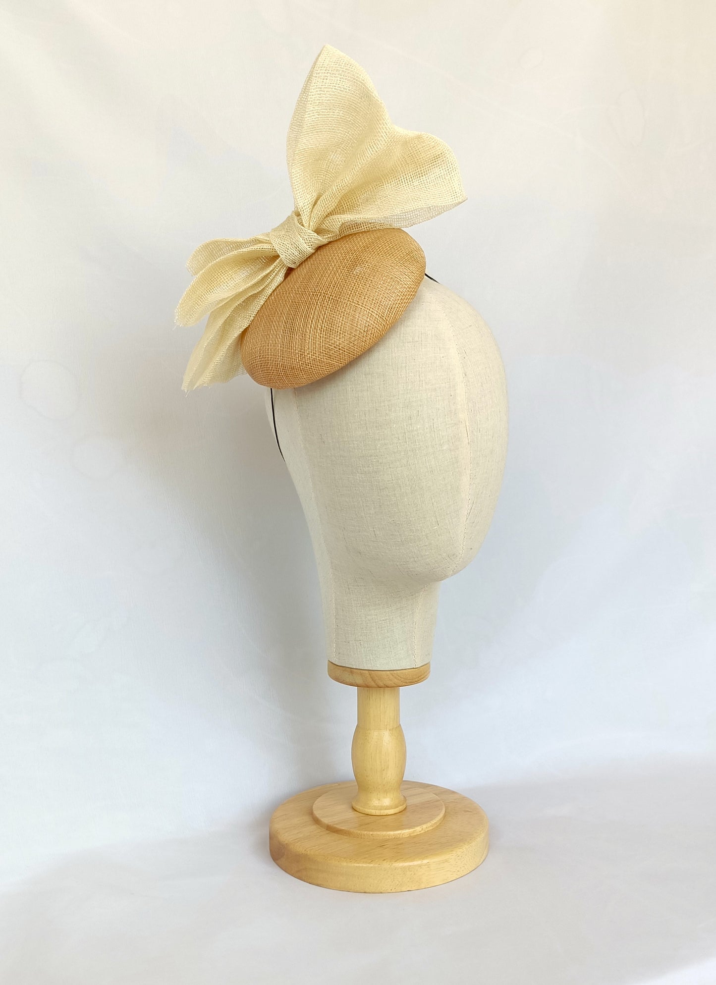 Tocado tipo botón en sinamay natural con lazo marfil – Elegante, rústico y coqueto para invitada de boda o evento de verano