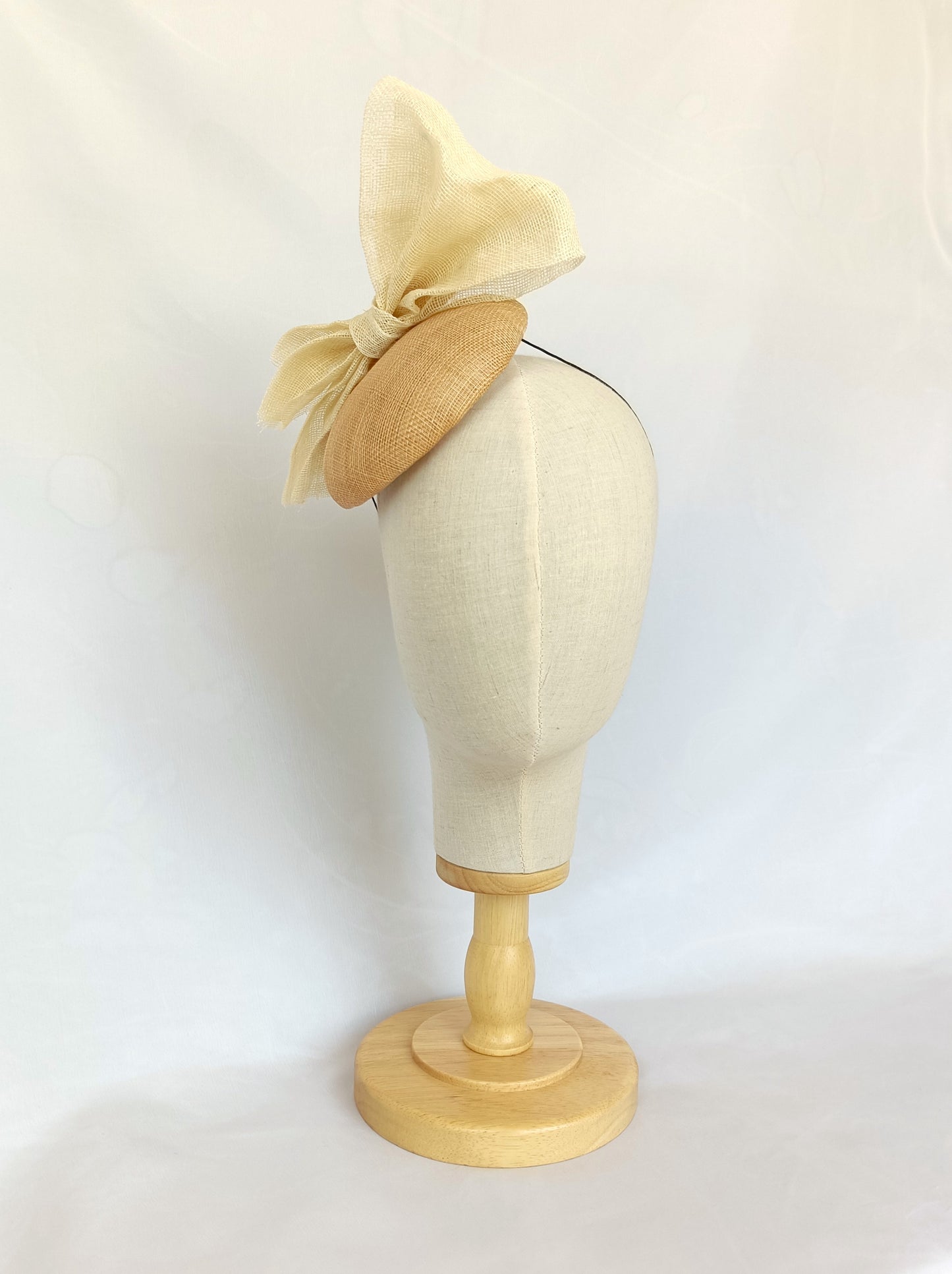 Tocado tipo botón en sinamay natural con lazo marfil – Elegante, rústico y coqueto para invitada de boda o evento de verano