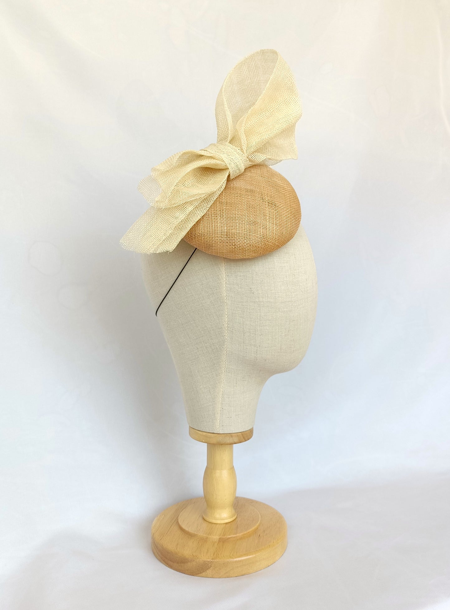 Tocado tipo botón en sinamay natural con lazo marfil – Elegante, rústico y coqueto para invitada de boda o evento de verano