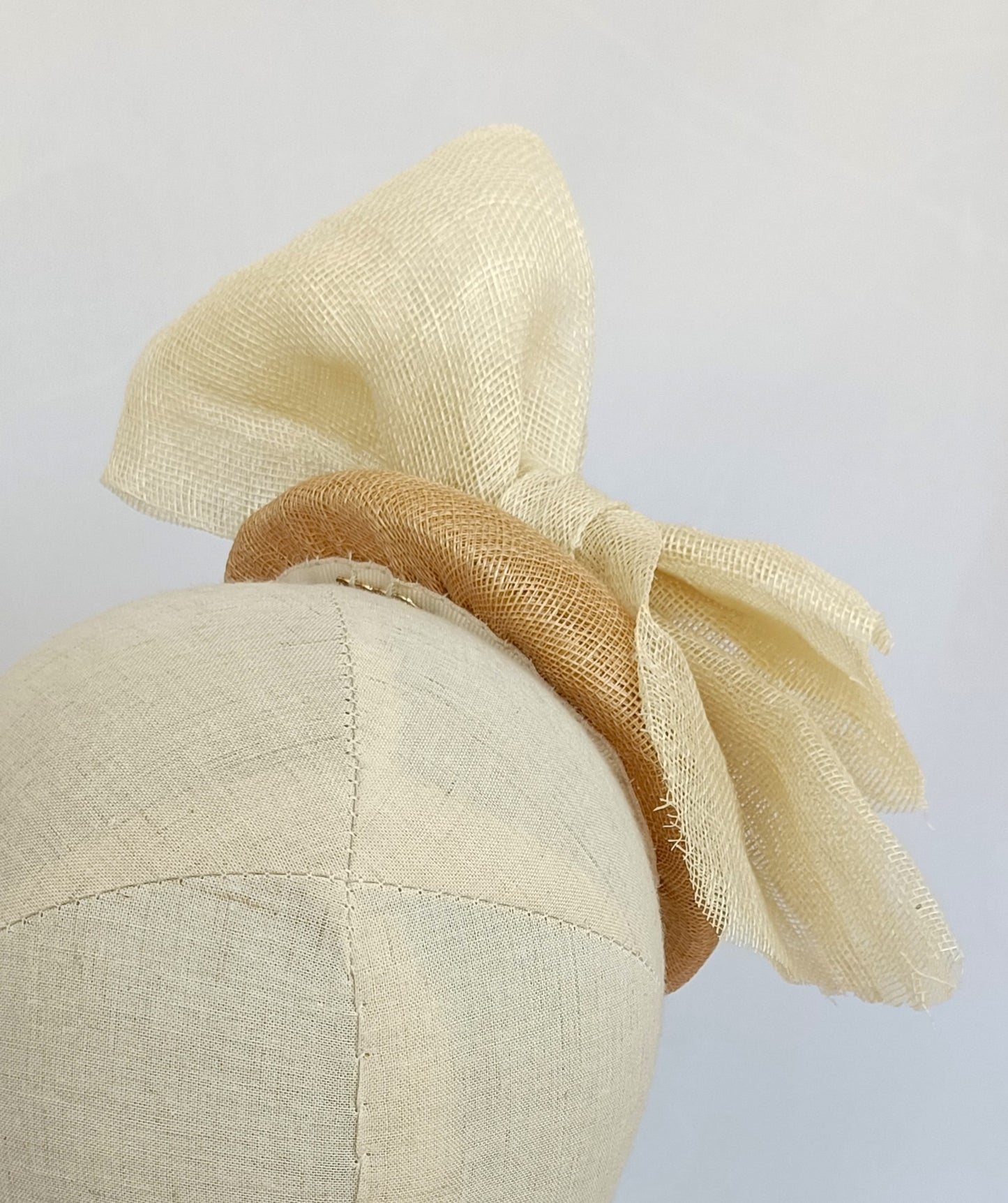 Tocado tipo botón en sinamay natural con lazo marfil – Elegante, rústico y coqueto para invitada de boda o evento de verano