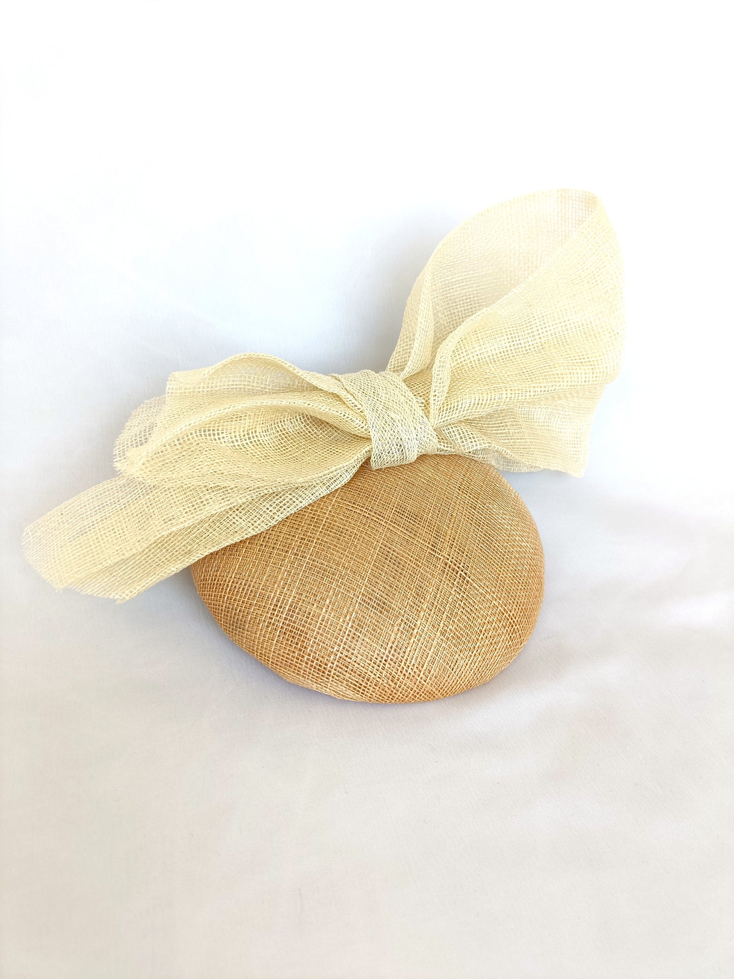 Tocado tipo botón en sinamay natural con lazo marfil – Elegante, rústico y coqueto para invitada de boda o evento de verano