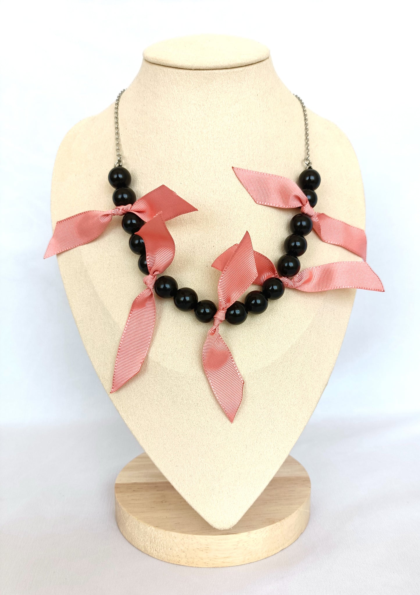 Collar de cuentas de ónix negro, cintas rosa palo.