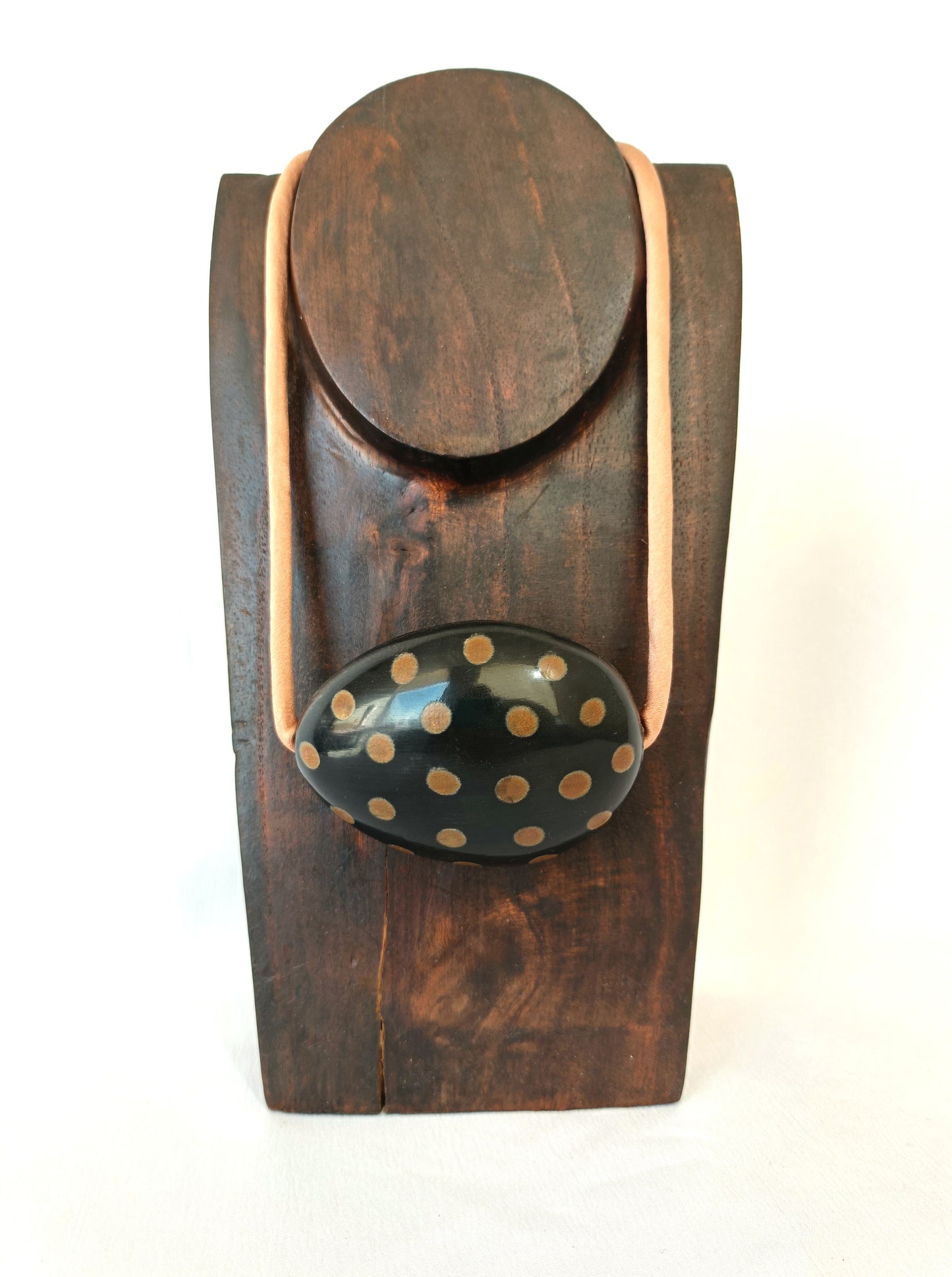 Collar corto con cuenta de cuerno negra y lunares tostados.