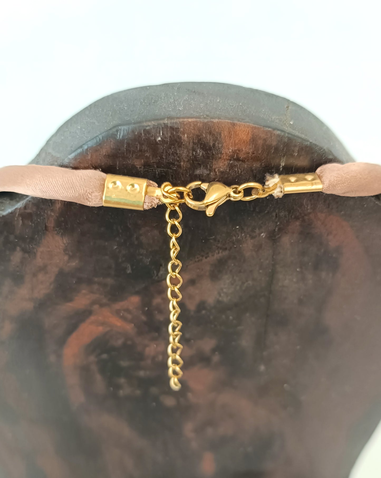 Collar corto con cuenta de cuerno negra y lunares tostados.
