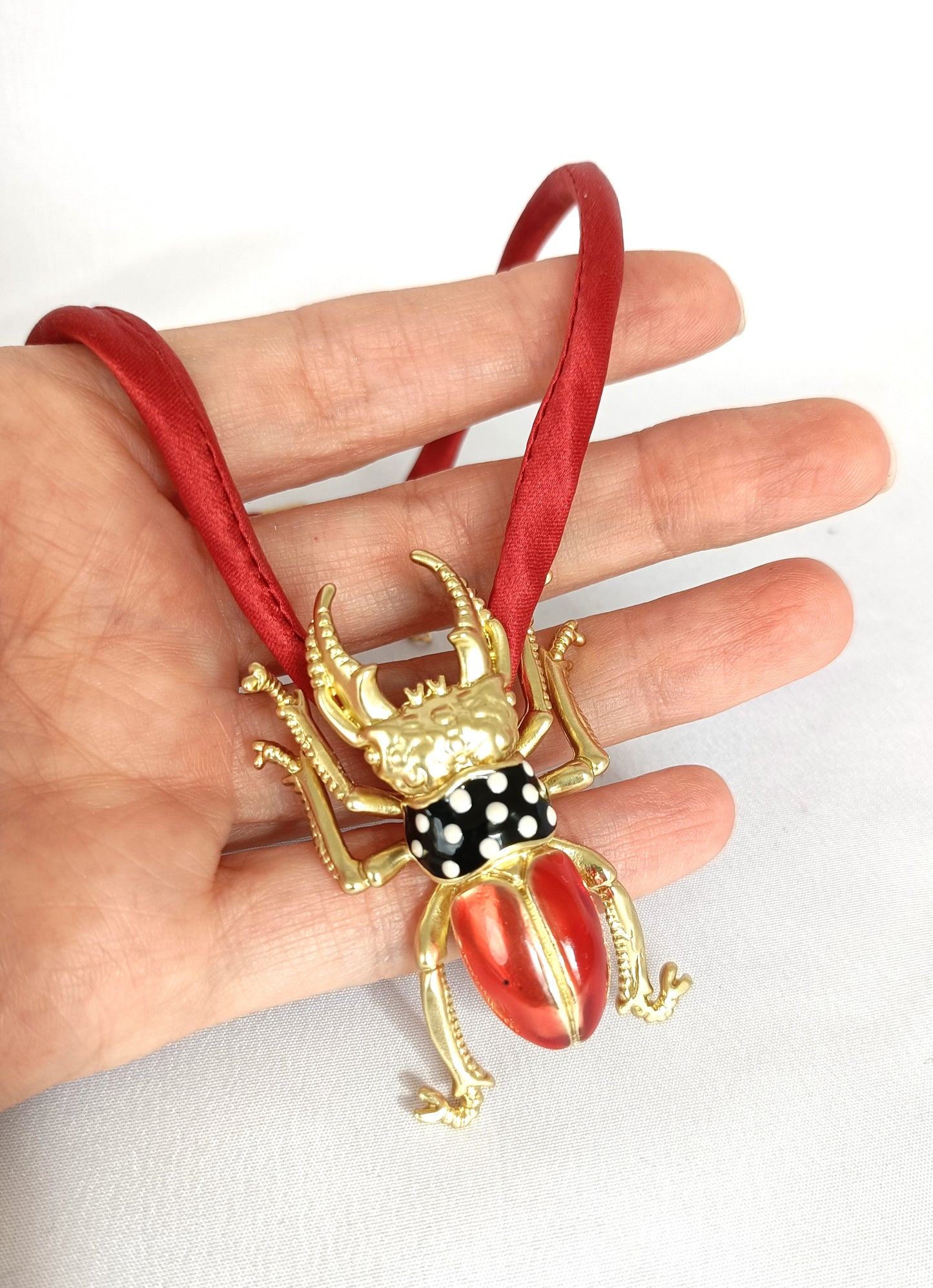 Collar escarabajo dorado y rojo con cordón de seda natural.