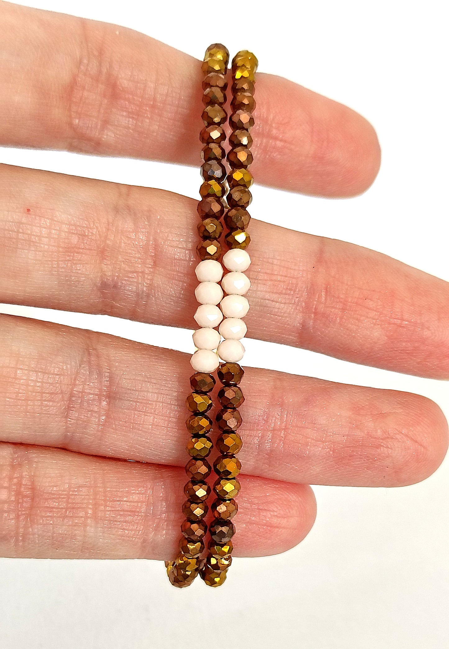 Pulsera doble de cristal en tonos bronce y blanco.