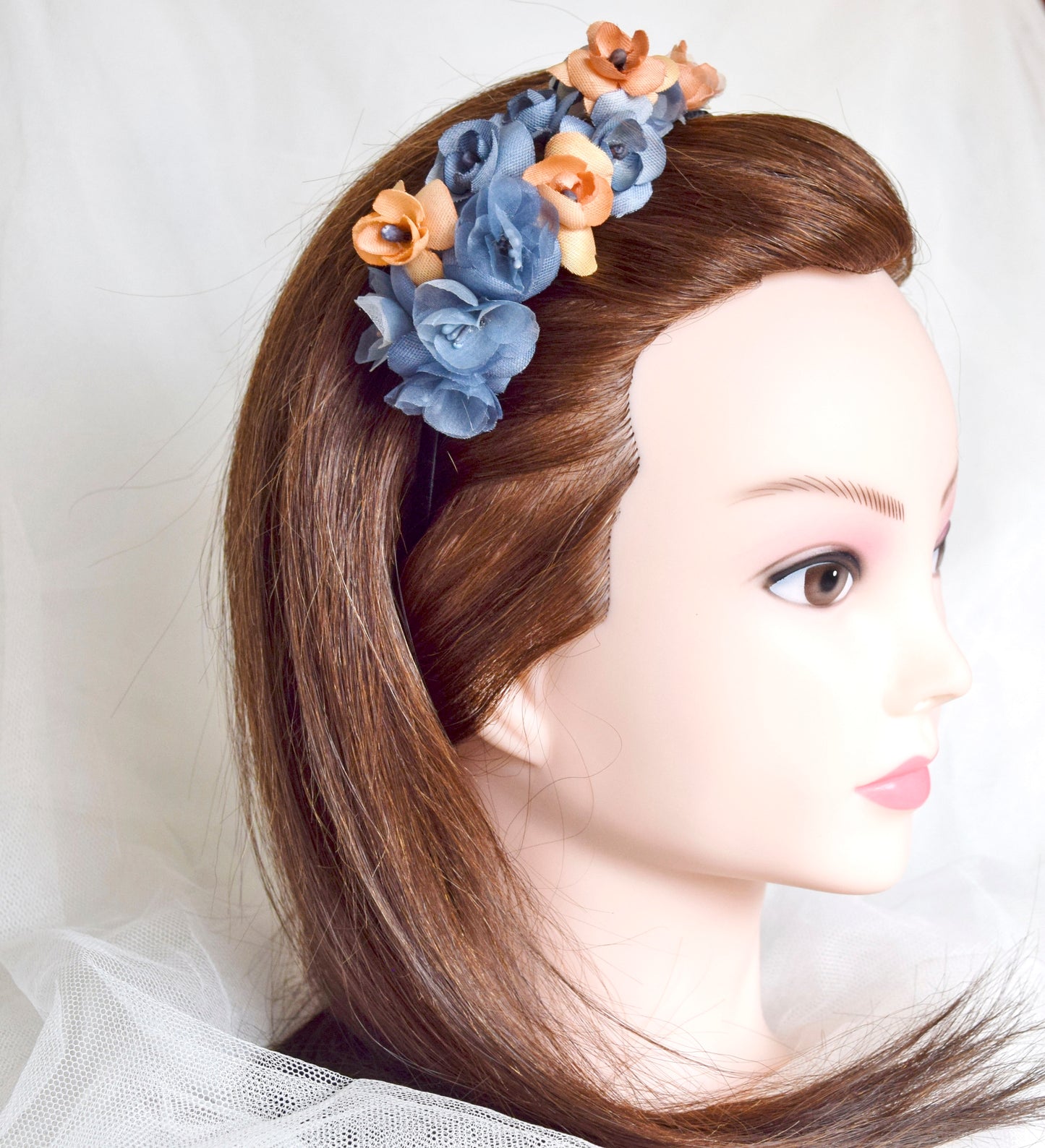 Diadema de flores de seda en azul y naranja, diseño elegante y romántico para invitada de boda o evento especial.
