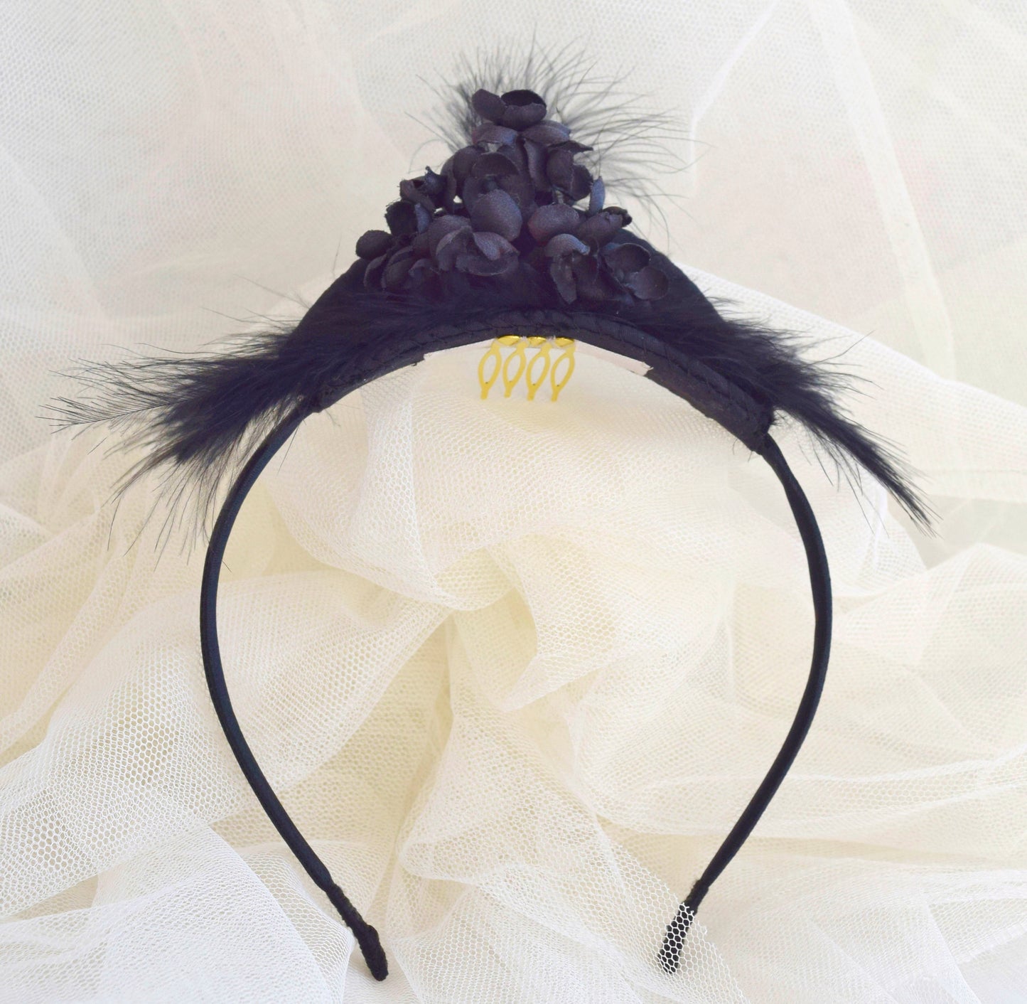 Tocado de flores y plumas negras.