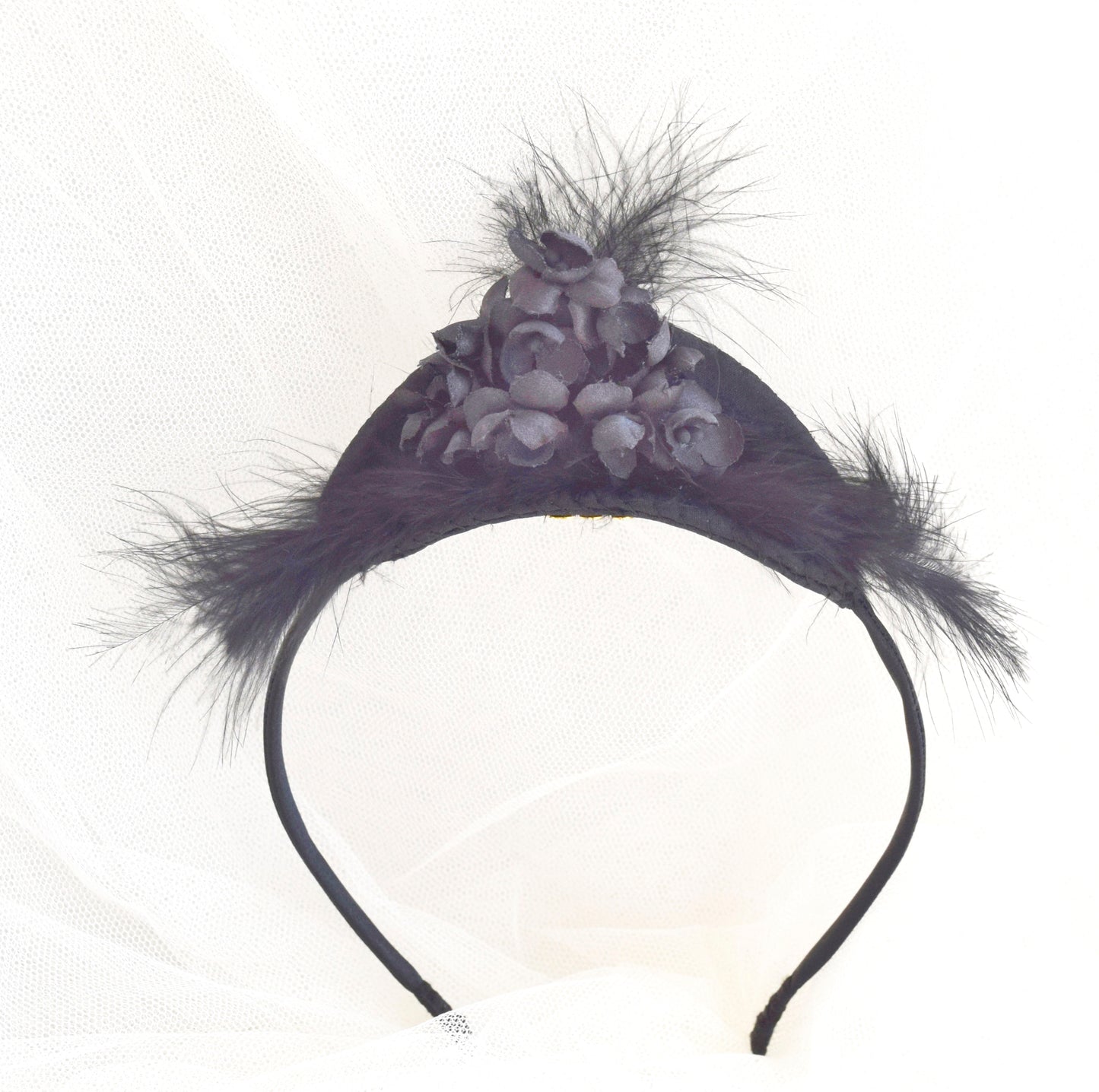 Tocado de flores y plumas negras.