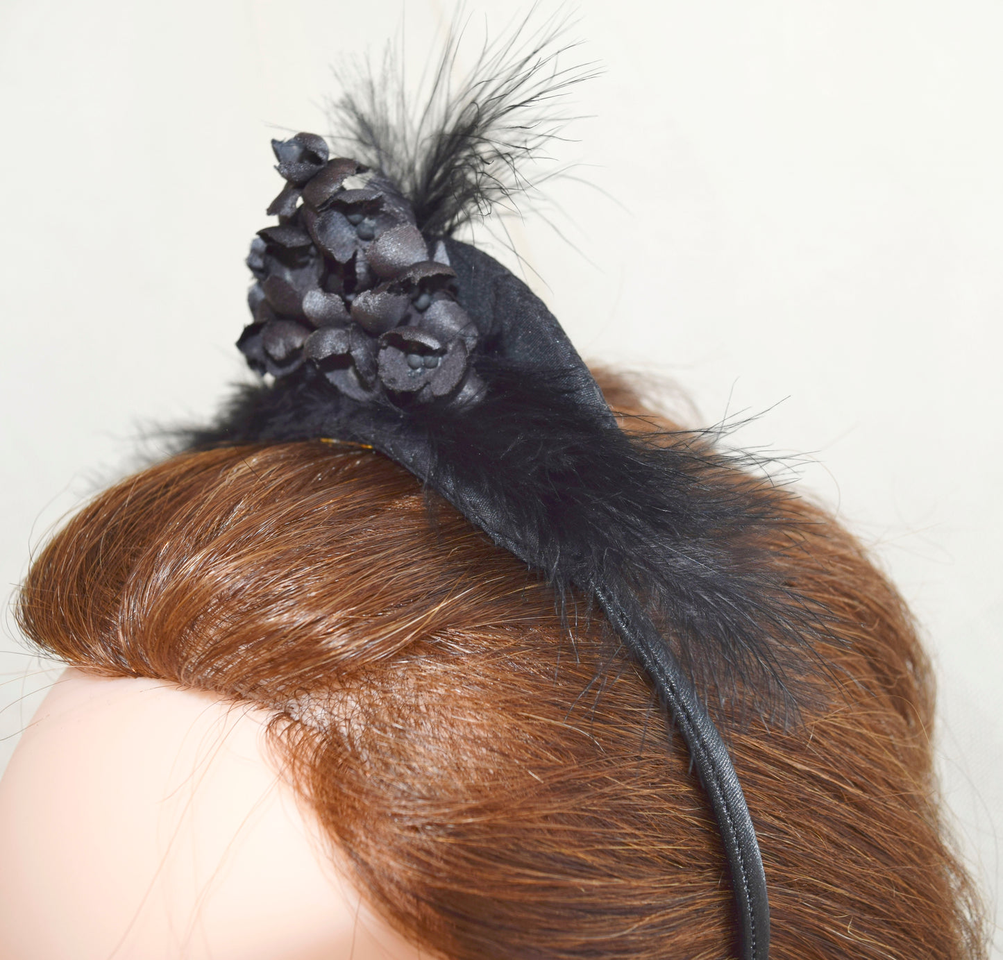 Tocado de flores y plumas negras.