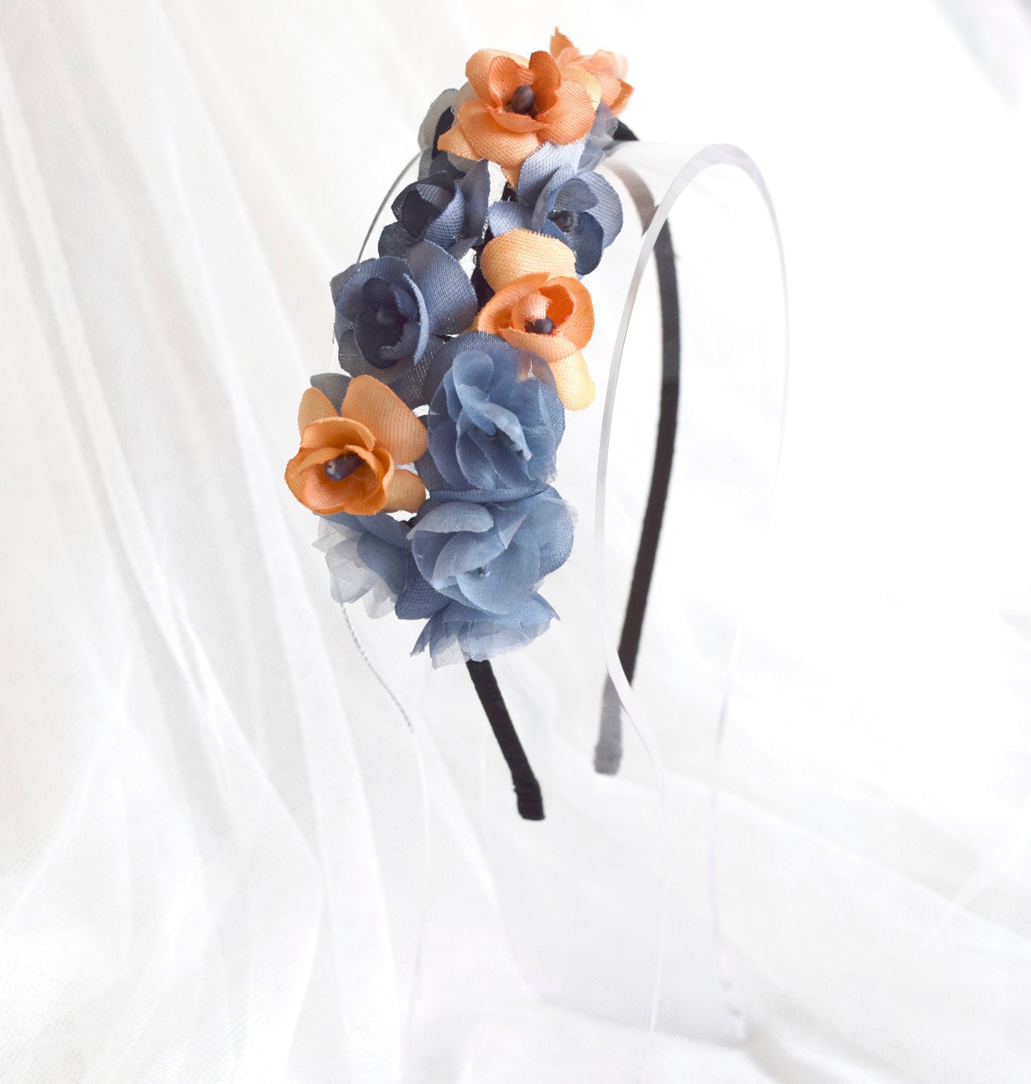 Diadema de flores de seda en azul y naranja, diseño elegante y romántico para invitada de boda o evento especial.