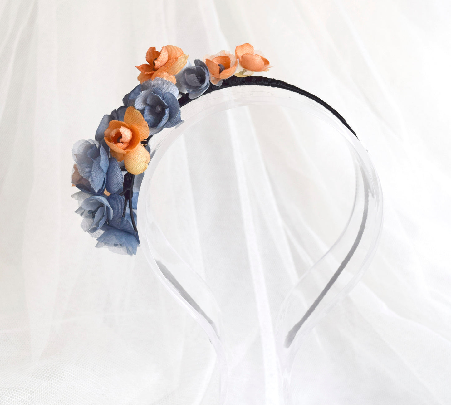 Diadema de flores de seda en azul y naranja, diseño elegante y romántico para invitada de boda o evento especial.