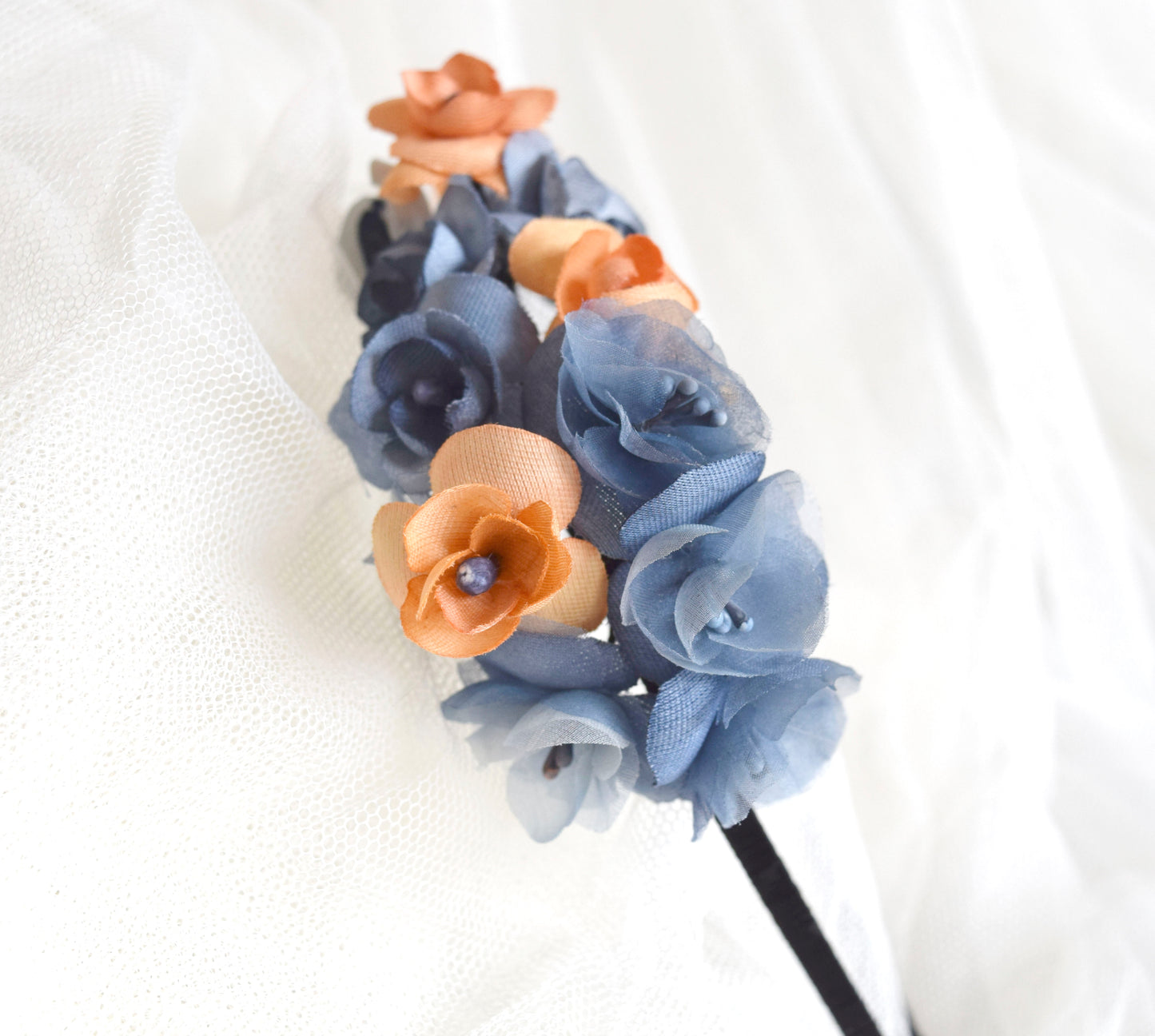 Diadema de flores de seda en azul y naranja, diseño elegante y romántico para invitada de boda o evento especial.
