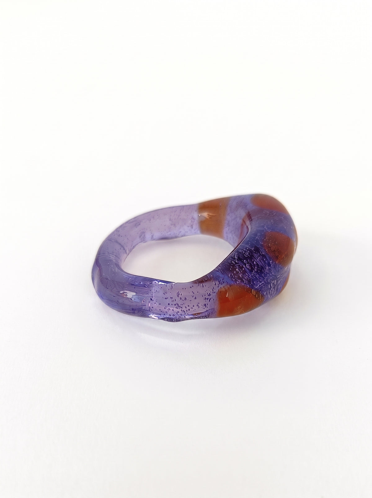 Anillo de vidrio morado translúcido con manchas naranjas