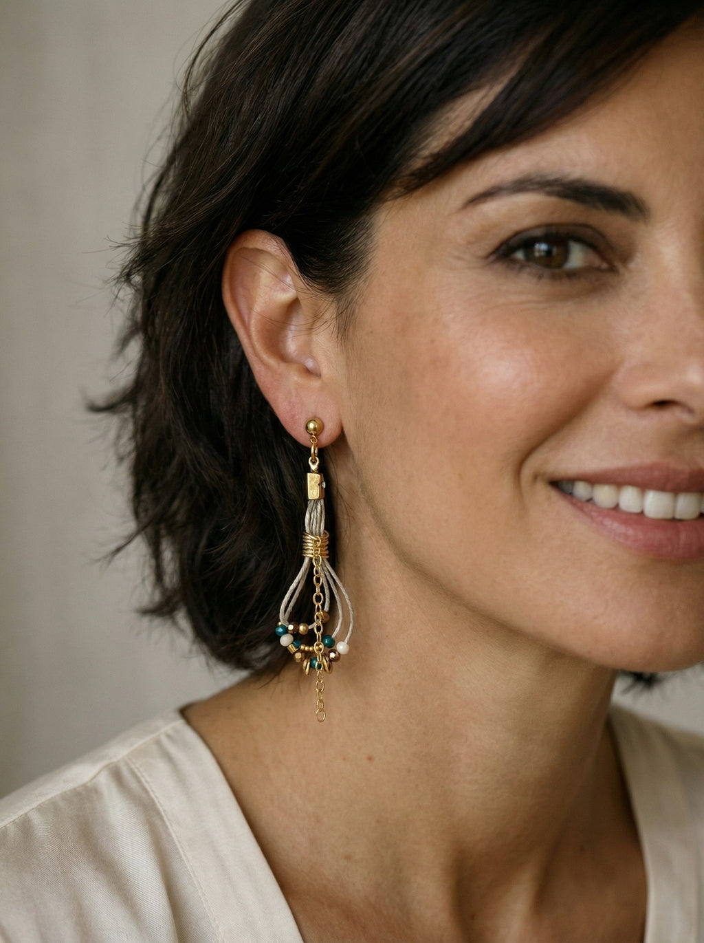 Pendientes de hilo de lino con cuentas en tonos azul y dorado.