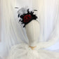Tocado negro con flor de terciopelo rojo, plumas y velo decorativo, estilo elegante y vintage para invitada de boda.