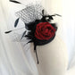 Tocado negro con flor de terciopelo rojo, plumas y velo decorativo, estilo elegante y vintage para invitada de boda.