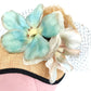 Tocado de sinamay con flores de seda y velo para invitada.