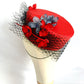 Tocado pillbox rojo de seda con flores artesanales.