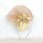Tocado elegante beige de sinamay con flor de seda para bodas.