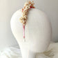 Diadema de flores preservadas en tonos rosa, blanco y beige