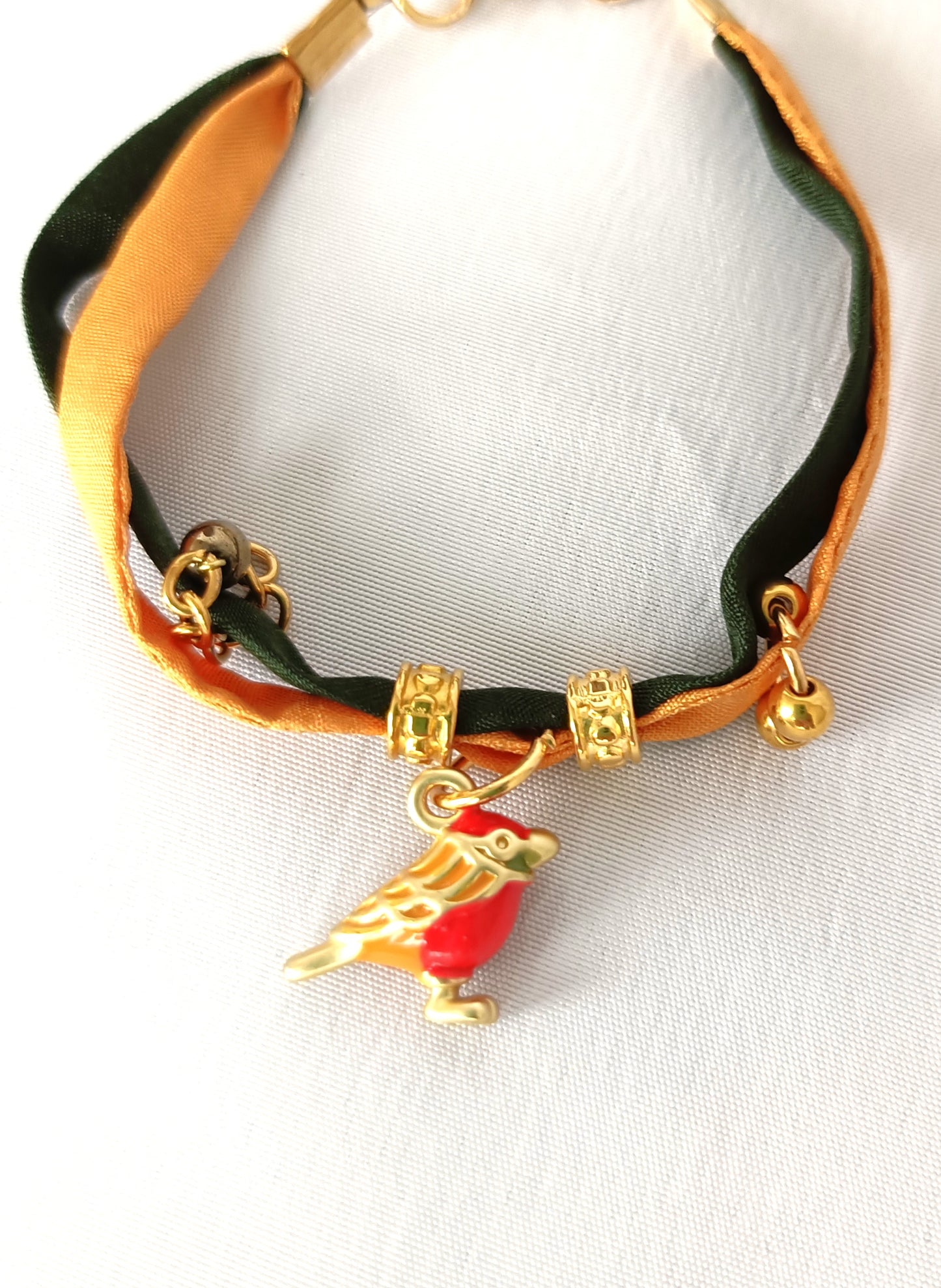 Pulsera de seda verde y mostaza con pajarita esmaltada