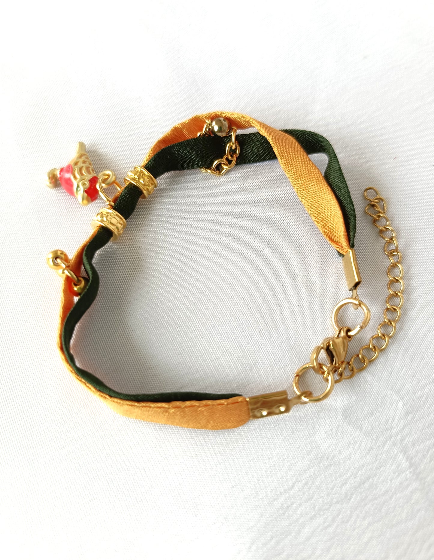 Pulsera de seda verde y mostaza con pajarita esmaltada