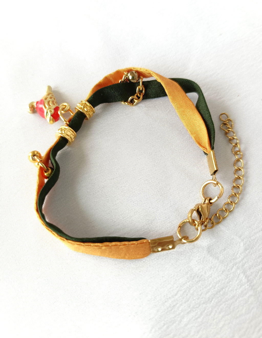 Pulsera de seda verde y mostaza con pajarita esmaltada